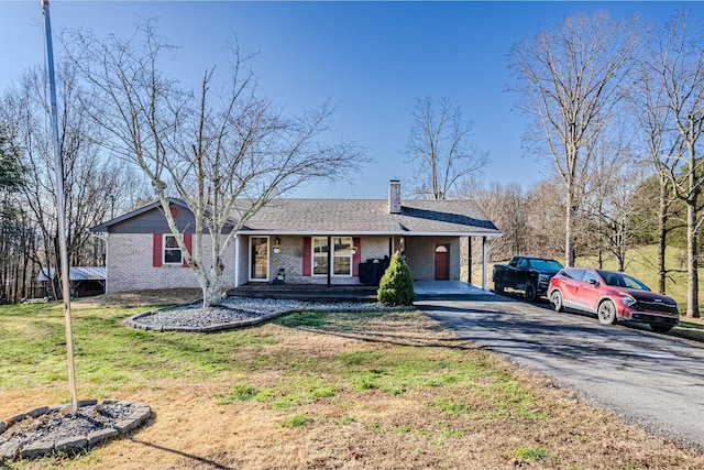 ranch-style house featuring a carport and a front lawn