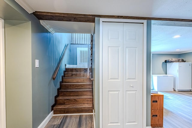 staircase with crown molding and hardwood / wood-style floors