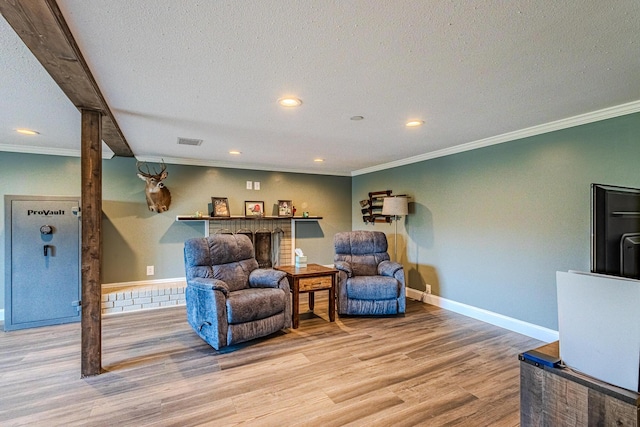 living area featuring crown molding, a textured ceiling, and light wood-type flooring