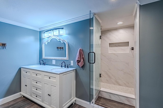 bathroom with crown molding, wood-type flooring, an enclosed shower, and vanity