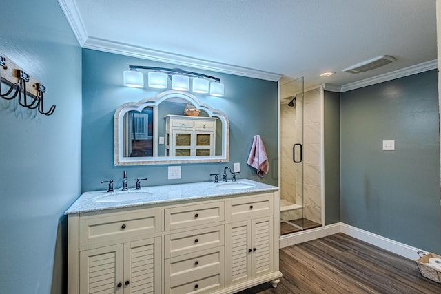 bathroom featuring walk in shower, ornamental molding, wood-type flooring, and vanity