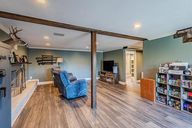 living room with hardwood / wood-style flooring, ornamental molding, and a textured ceiling