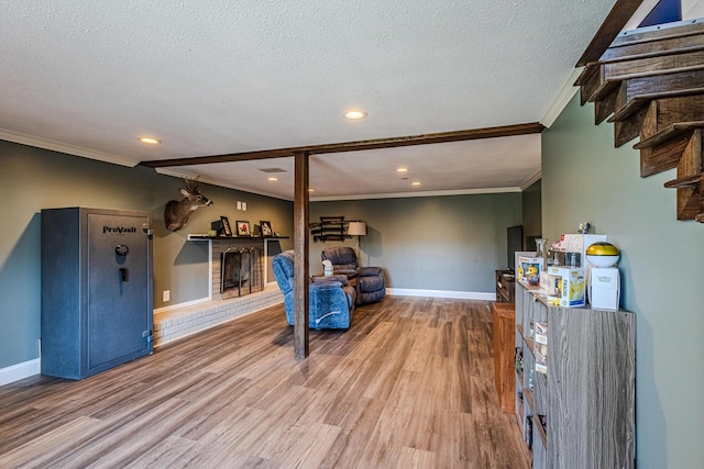 sitting room featuring hardwood / wood-style flooring, crown molding, and a textured ceiling