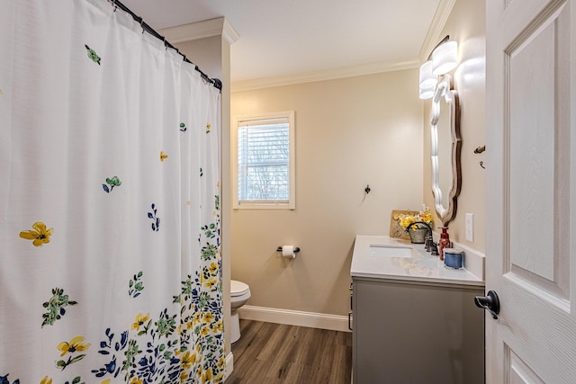 bathroom with crown molding, vanity, toilet, and hardwood / wood-style flooring