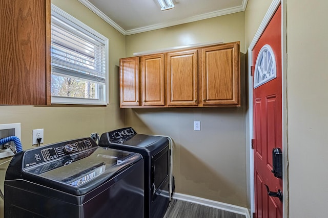 laundry room featuring crown molding, cabinets, dark hardwood / wood-style flooring, and washing machine and dryer