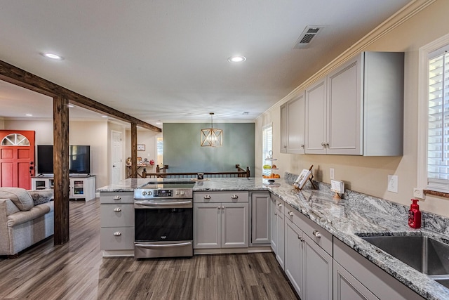 kitchen featuring sink, electric range, dark hardwood / wood-style floors, kitchen peninsula, and pendant lighting