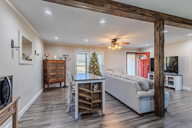 living room featuring dark hardwood / wood-style flooring, ornamental molding, and ceiling fan