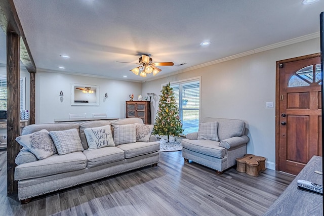 living room featuring crown molding, ceiling fan, and dark hardwood / wood-style flooring