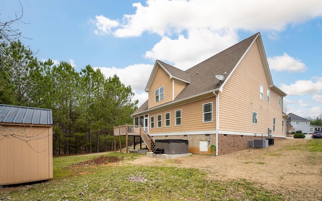 back of property featuring cooling unit, a lawn, a hot tub, and a deck