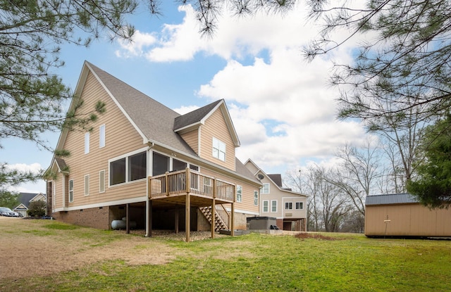 rear view of house featuring a wooden deck, a yard, and a sunroom