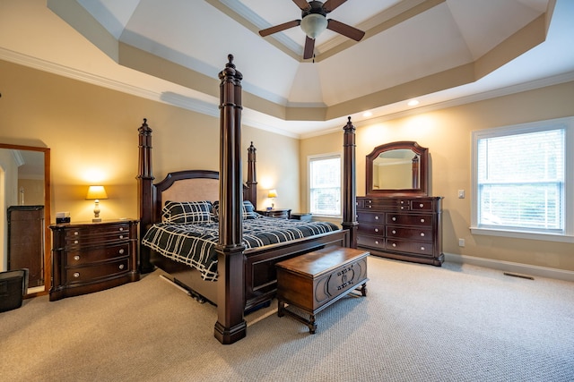 bedroom with ornamental molding, light colored carpet, a raised ceiling, and ceiling fan