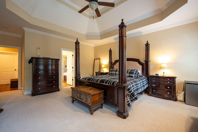 carpeted bedroom featuring ceiling fan, ornamental molding, a tray ceiling, and ensuite bathroom