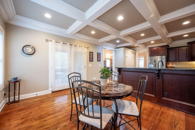 dining area featuring coffered ceiling, beam ceiling, and light wood-type flooring