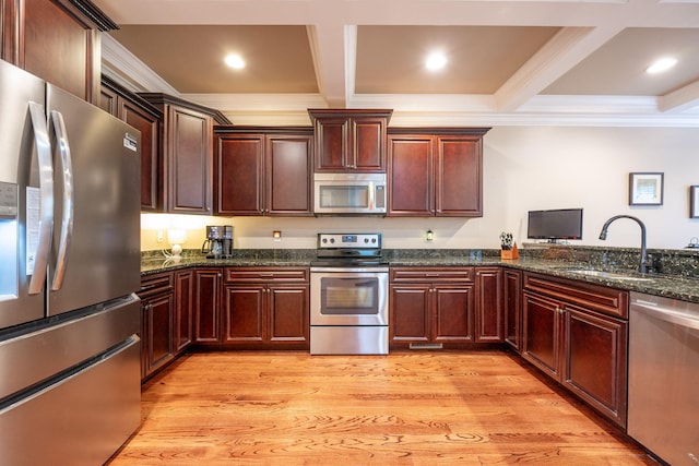 kitchen with coffered ceiling, appliances with stainless steel finishes, sink, and light hardwood / wood-style floors