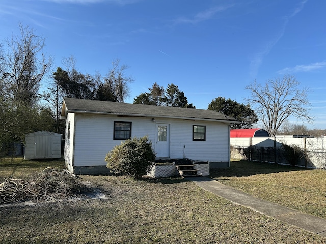 view of front facade with a storage shed and a front lawn