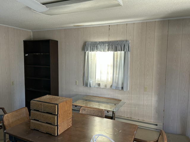 dining area with crown molding, a textured ceiling, and baseboard heating