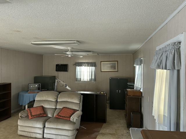 living room with ceiling fan, a wall mounted AC, and a textured ceiling