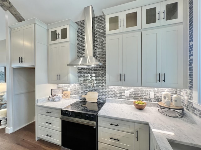 kitchen featuring black electric range, wall chimney exhaust hood, and decorative backsplash