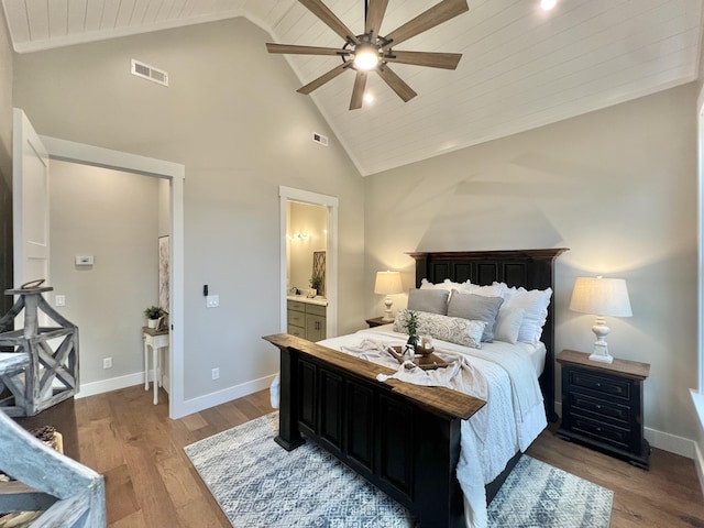 bedroom with high vaulted ceiling, light wood-type flooring, wood ceiling, baseboards, and connected bathroom
