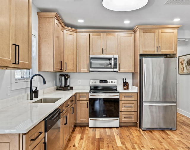 kitchen with sink, light hardwood / wood-style flooring, stainless steel appliances, and light brown cabinets