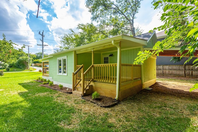 view of side of property with a yard and covered porch