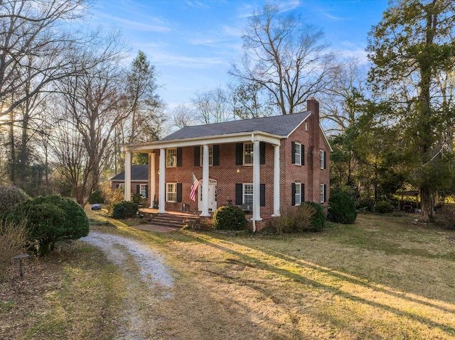 neoclassical home featuring a front yard