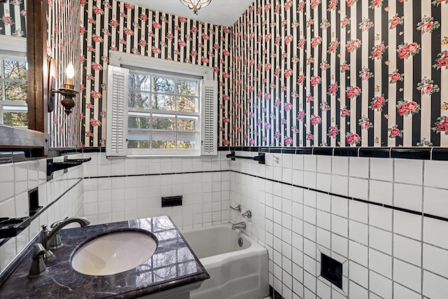 bathroom featuring vanity, a healthy amount of sunlight, tile walls, and a bathtub