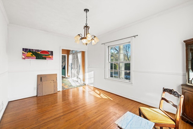 unfurnished dining area with hardwood / wood-style floors, crown molding, and a notable chandelier