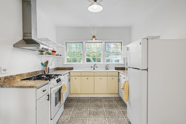 kitchen featuring sink, white appliances, and wall chimney exhaust hood