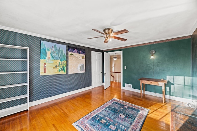 unfurnished room featuring hardwood / wood-style flooring, ornamental molding, and ceiling fan