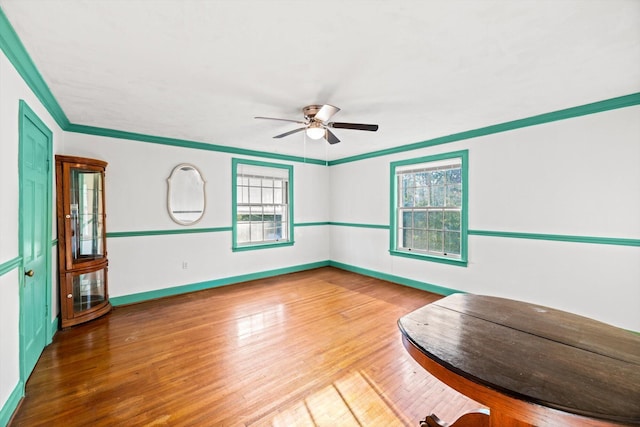 spare room featuring ceiling fan, ornamental molding, plenty of natural light, and hardwood / wood-style floors