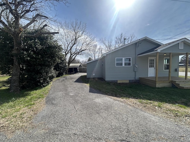 view of side of home featuring a porch, crawl space, and an outdoor structure