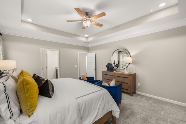 bedroom with light carpet, ceiling fan, and a tray ceiling