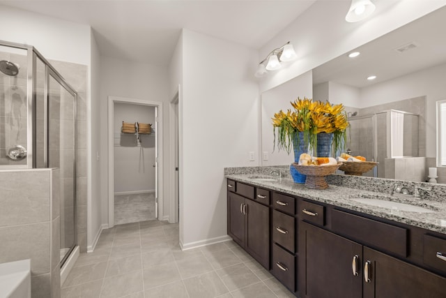 bathroom with vanity, a shower with shower door, and tile patterned floors