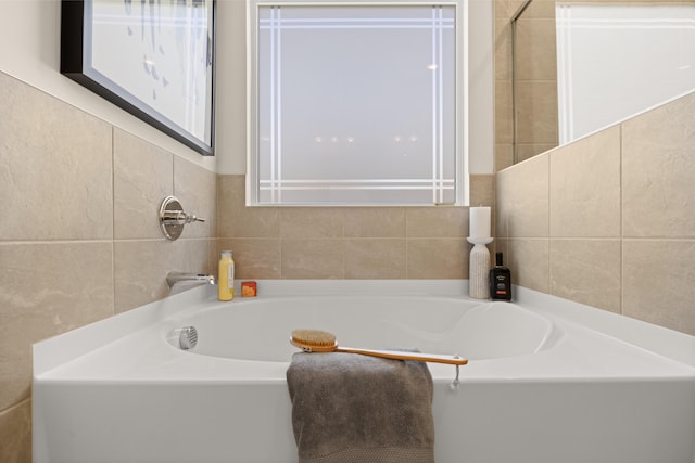 bathroom featuring tile walls and a washtub