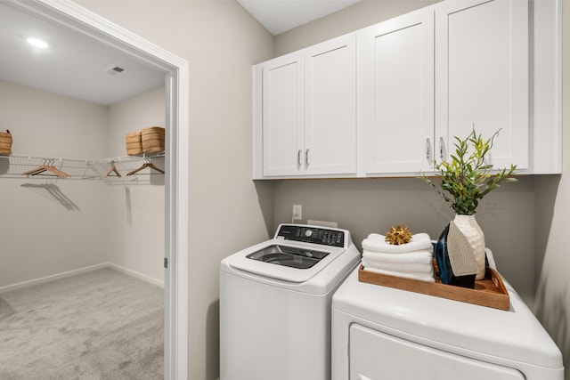 washroom with light carpet, washer and clothes dryer, and cabinets