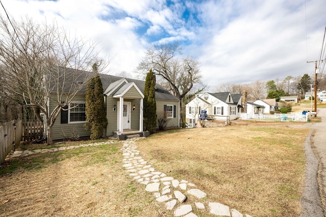 view of front of property with a front lawn, a chimney, fence, and a residential view