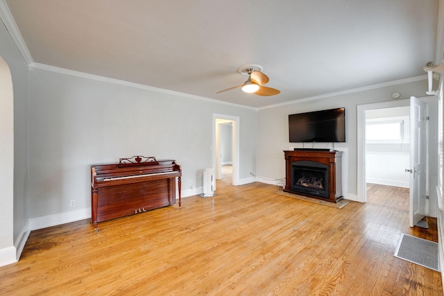 living room featuring light wood-type flooring, crown molding, radiator heating unit, and ceiling fan