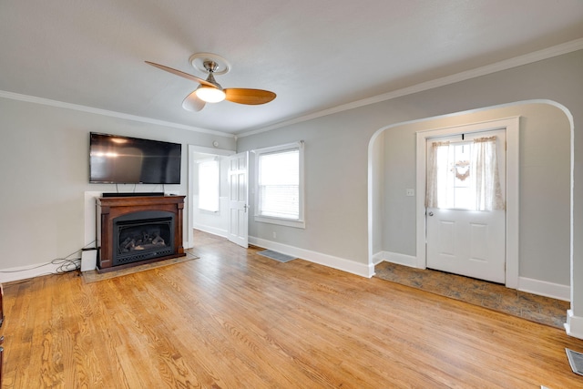 unfurnished living room featuring light wood-type flooring, crown molding, and ceiling fan