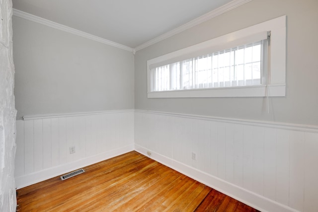 unfurnished room with crown molding and wood-type flooring