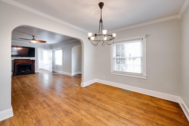 unfurnished living room with ornamental molding, light hardwood / wood-style floors, and ceiling fan with notable chandelier