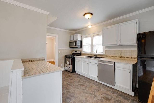 kitchen featuring white cabinetry, ornamental molding, appliances with stainless steel finishes, and sink