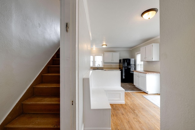 stairs with sink, ornamental molding, and hardwood / wood-style floors