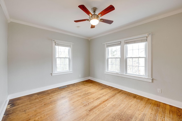 empty room featuring ceiling fan, hardwood / wood-style flooring, crown molding, and a healthy amount of sunlight