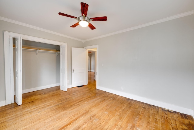 unfurnished bedroom featuring ceiling fan, light wood-type flooring, crown molding, and a closet