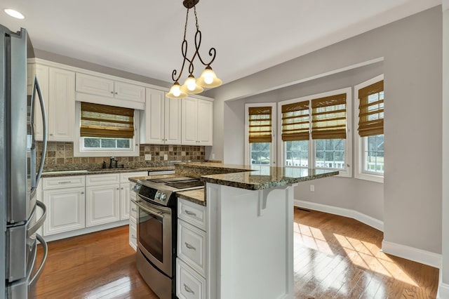 kitchen with a sink, decorative backsplash, appliances with stainless steel finishes, and white cabinetry