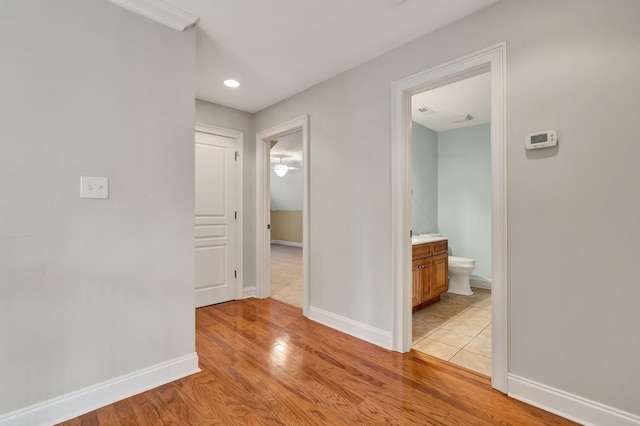 hallway featuring light wood-type flooring and baseboards