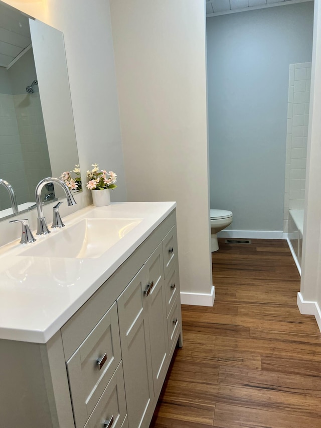 full bath featuring toilet, wood finished floors, visible vents, baseboards, and a shower