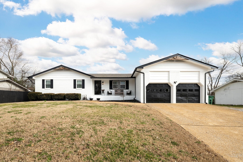 view of front of property with a porch, a garage, and a front yard