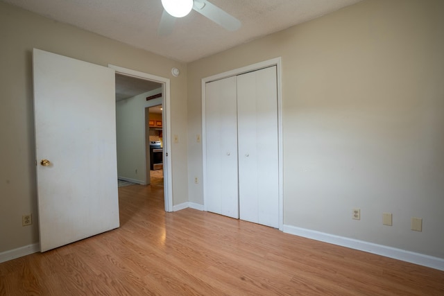 unfurnished bedroom featuring a textured ceiling, light hardwood / wood-style floors, a closet, and ceiling fan